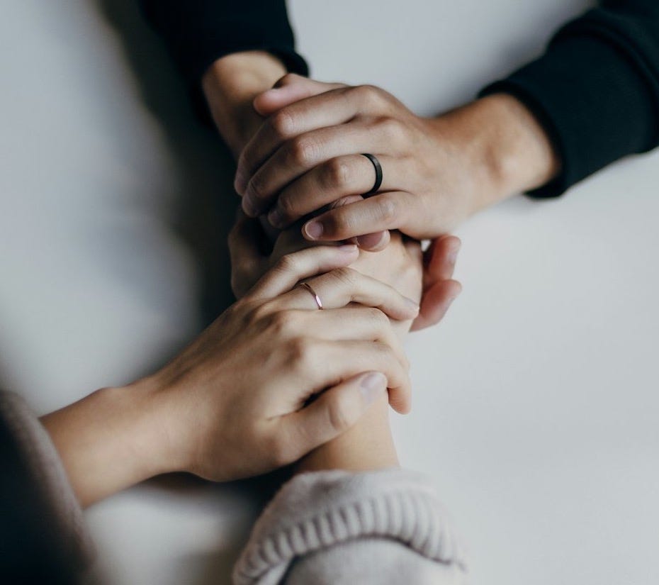 person in black long sleeve shirt holding babys feet person in black long sleeve shirt holding babys feet