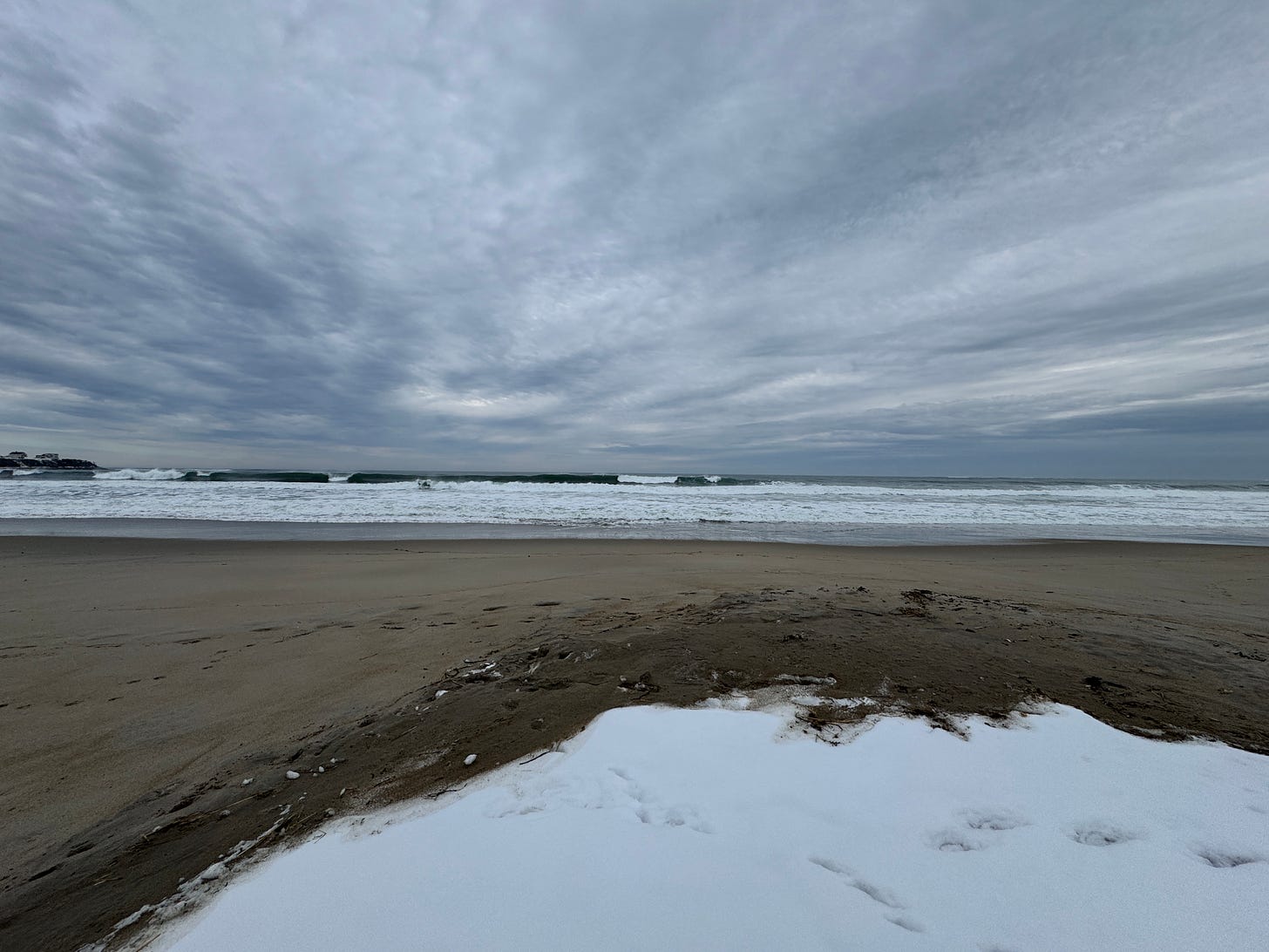 A beach in New England with snow.