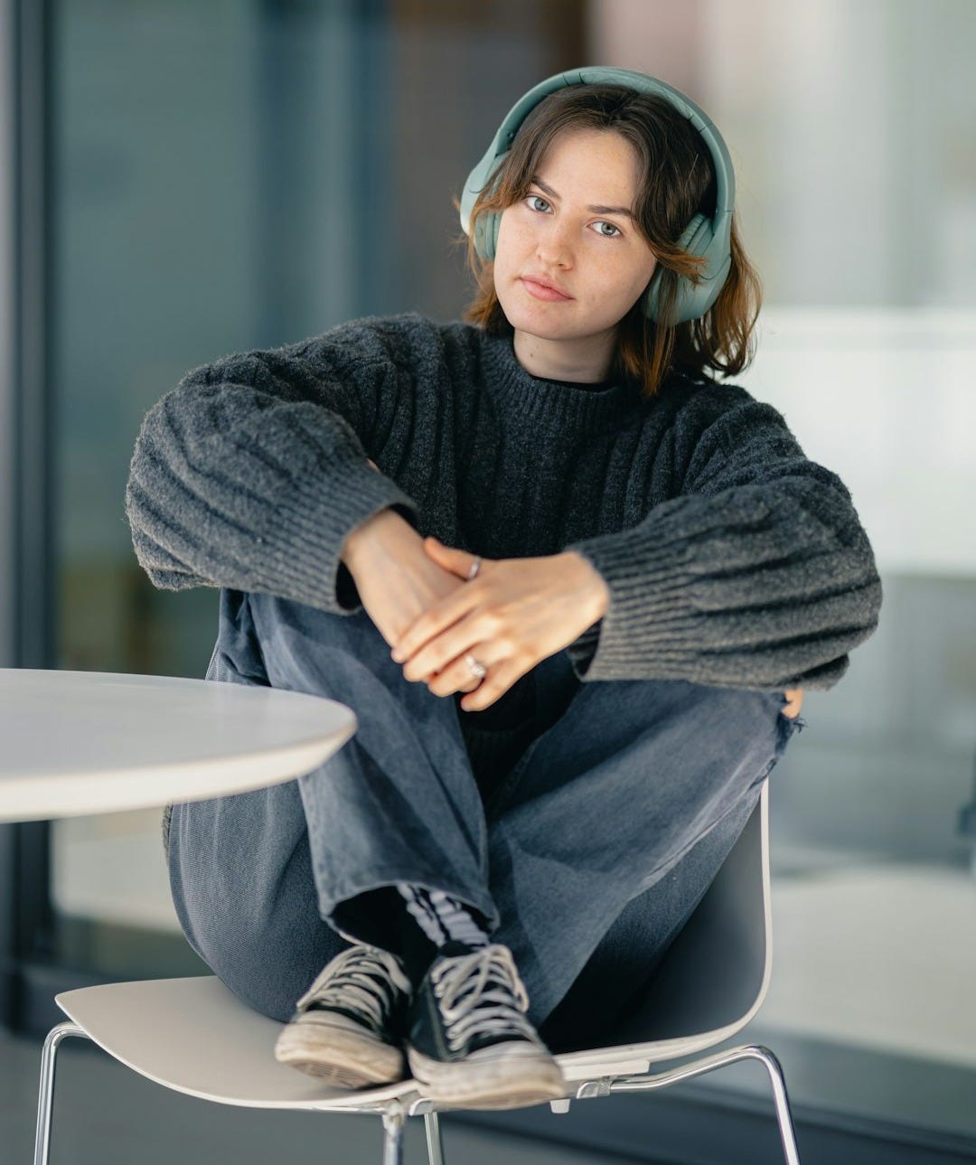 A woman sitting on a chair wearing headphones