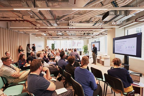 A man presenting to a room full of people.