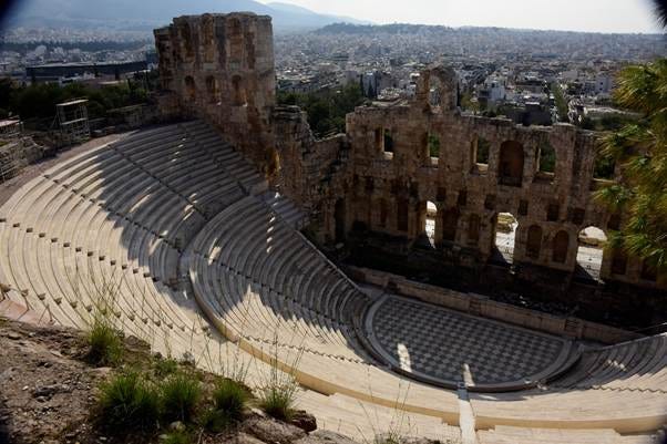 An old amphitheater with a city in the background

AI-generated content may be incorrect.