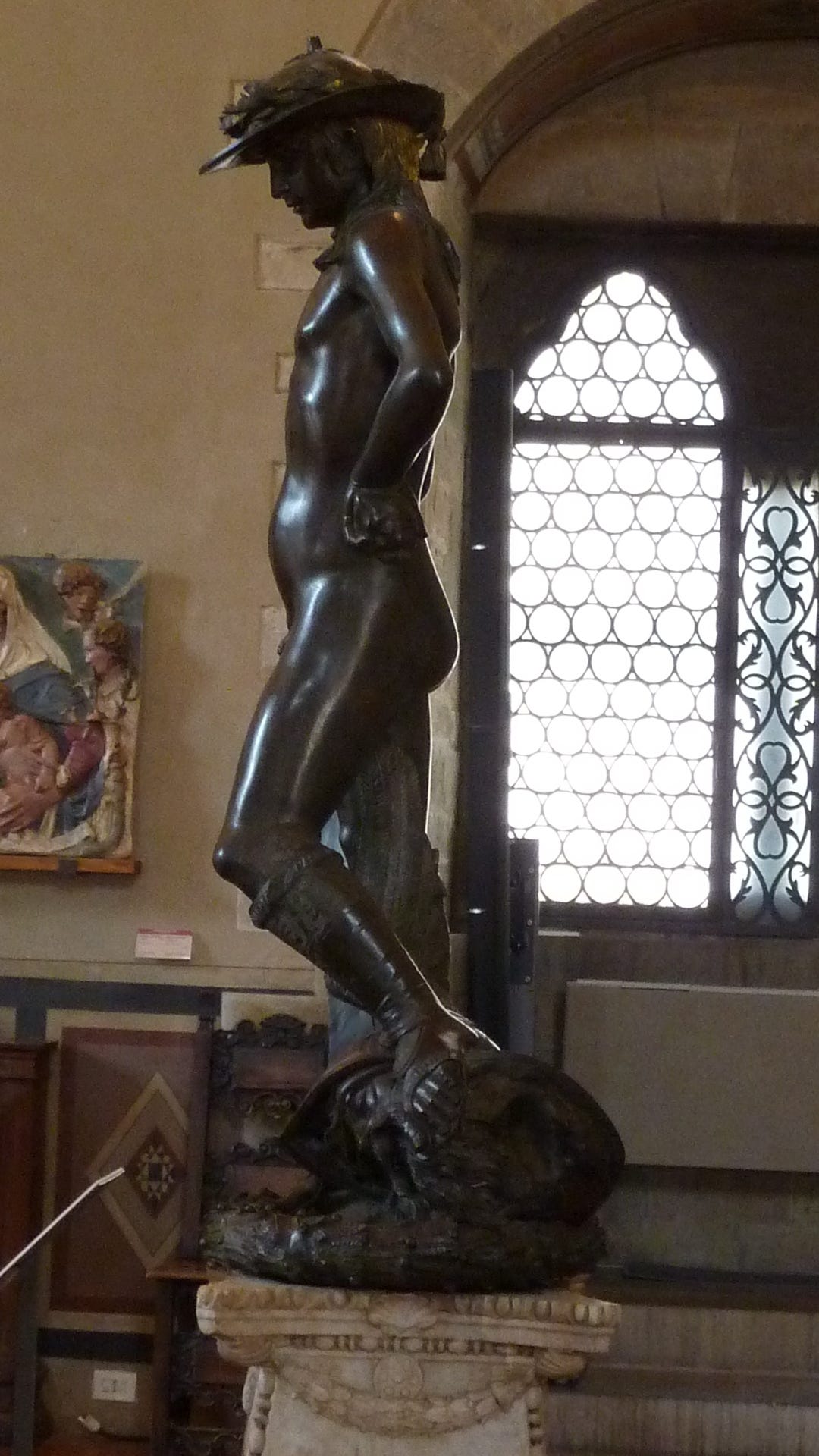 Bronze boy David in a hat on Goliath's head Bronze boy David in a hat on Goliath's head