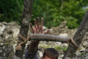 wounded man reaches up for help