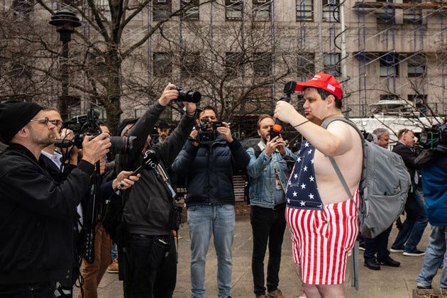 A Trump supporters poses for photographs before Former President Donald Trump arrives.