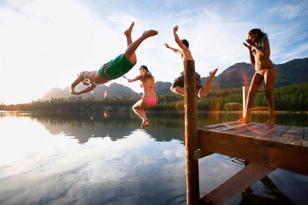 https://i2-prod.mirror.co.uk/incoming/article12812462.ece/ALTERNATES/s615b/Four-young-adults-diving-from-jetty-into-lake-at-sunset-side-view-lens-flare.jpg