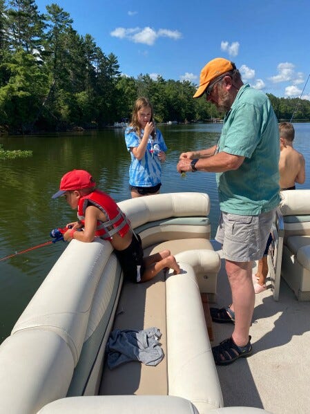 Tom LaDue baits a hook with his grandkids in 2022 before PFAS contamination was discovered in Snowden Lake in Stella, Wis. (Courtesy Tom LaDue via AP) Tom LaDue baits a hook with his grandkids in 2022 before PFAS contamination was discovered in Snowden Lake in Stella, Wis. (Courtesy Tom LaDue via AP)