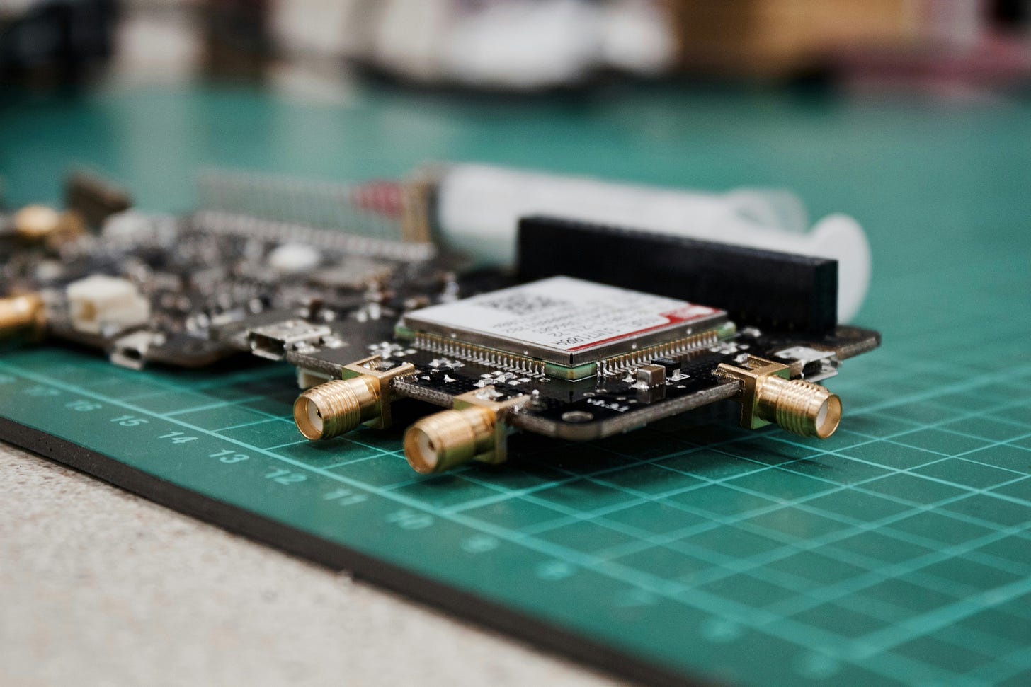 Dwie płytki PCB z widoczną elektroniką leżące na zielonej podkładce