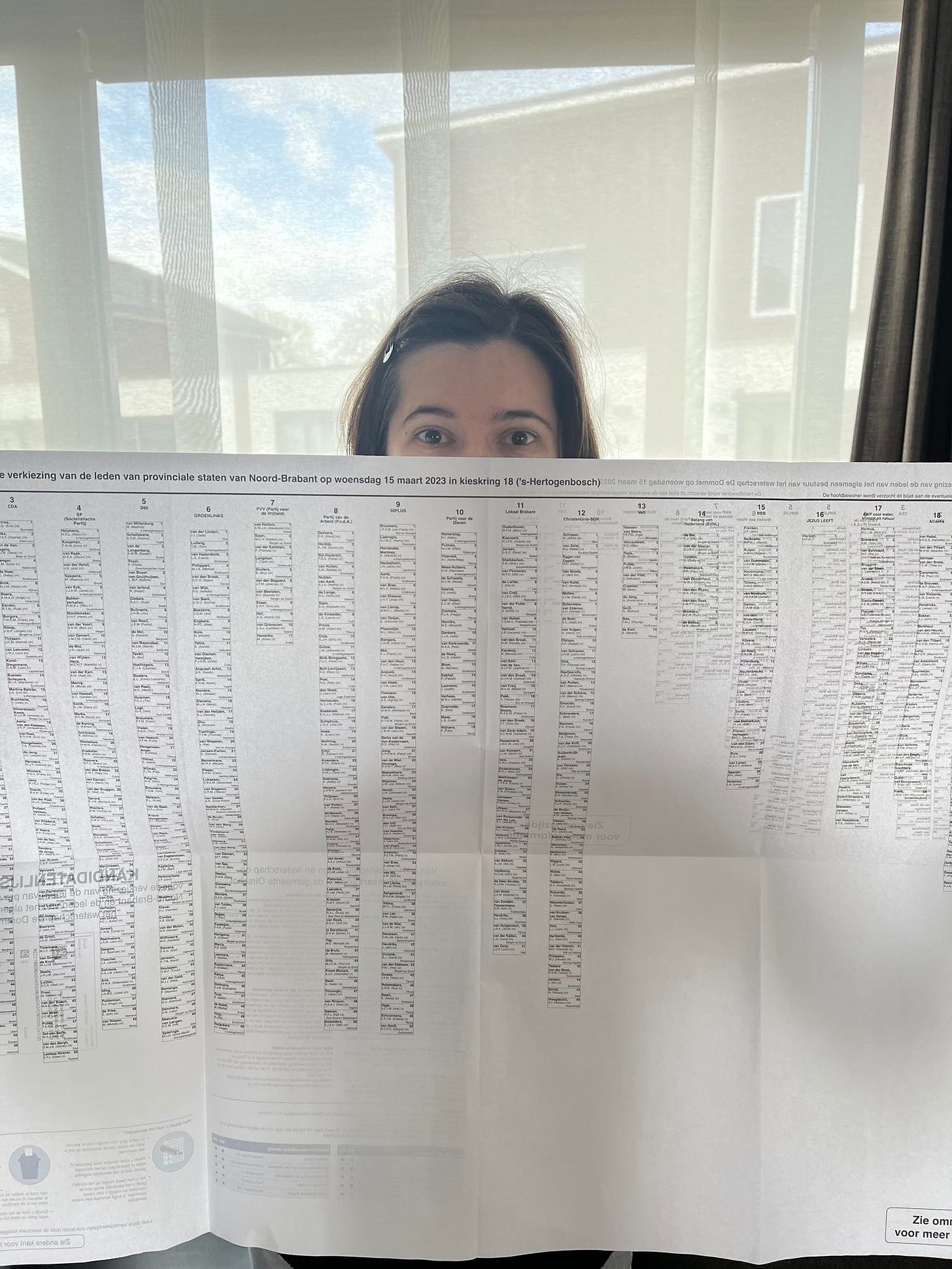 foto de mulher segurando um papel imenso, do tamanho de 8 folhas A4