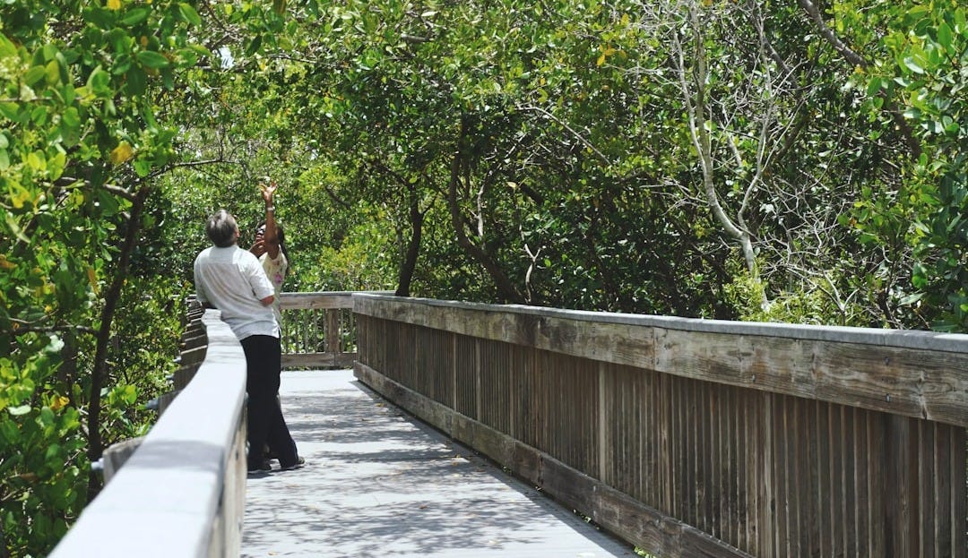 man wearing white shirt standing in bridge during daytime