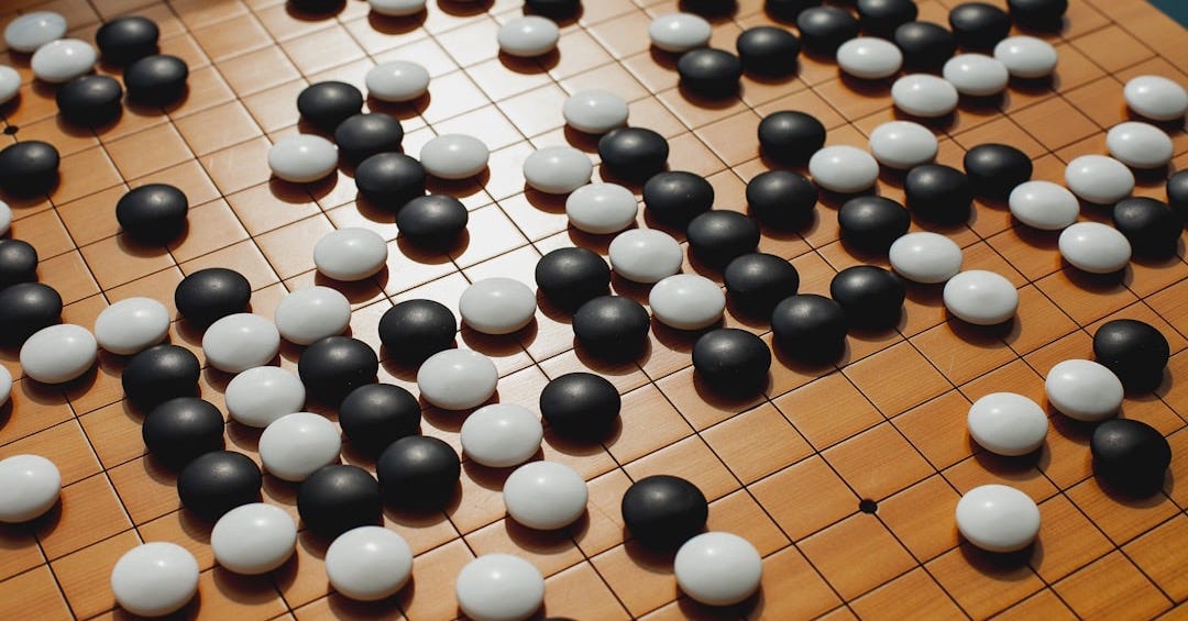 a close up of a board game with black and white balls