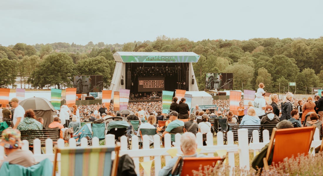 A wide shot of Splendour festival with crowds of people sitting down and a stage at the front