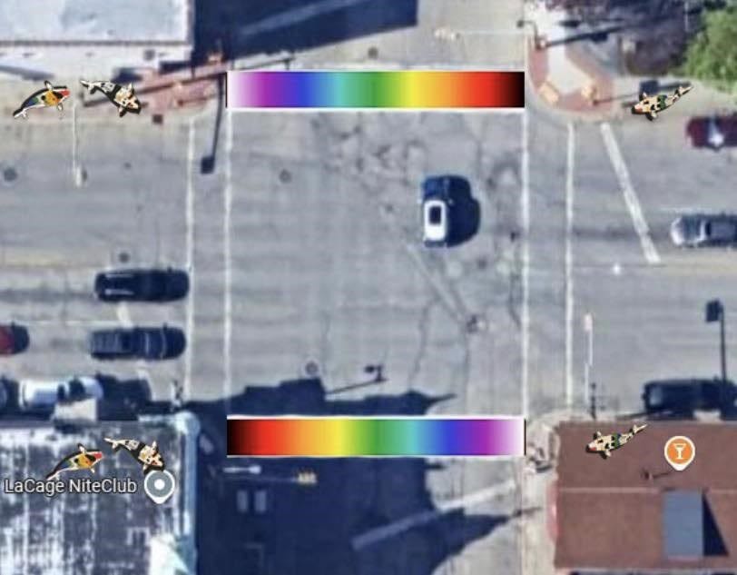 Aerial view of a vibrant rainbow-colored crosswalk, showcasing a colorful design in an urban setting.