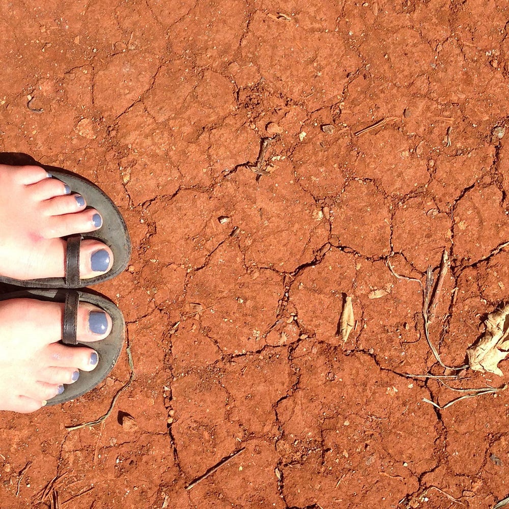 Sandled feet on red earth