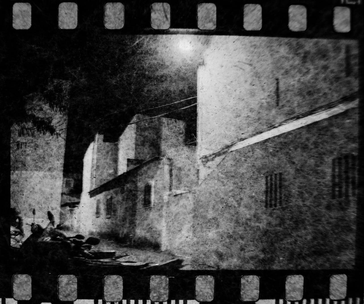 Black and white view of alleyways at night.