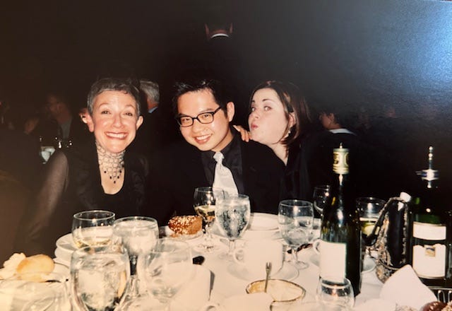 Three people in black clowing around at a banquet table Three people in black clowing around at a banquet table