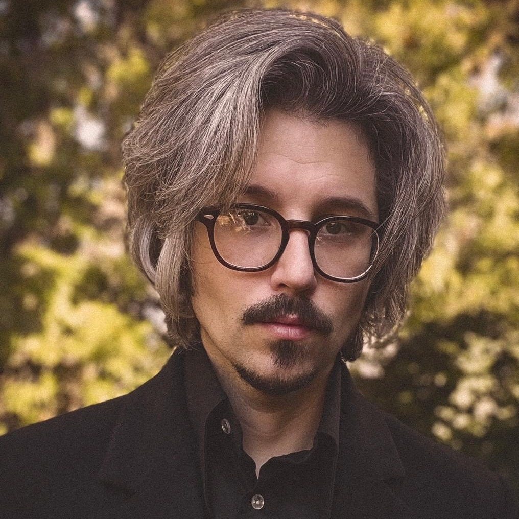 A portrait photograph of Scott Leeds wearing glasses and a dark shirt A portrait photograph of Scott Leeds wearing glasses and a dark shirt