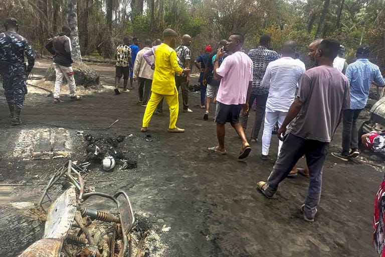 EDS NOTE: GRAPHIC CONTENT- People gather Saturday April 23, 2022 at the site of an explosion that took place the day before at an illegal oil refinery in Ohaji-Egbema local government area in Imo state, southeast Nigeria. At least 100 people are feared to have died in the explosion, authorities told The Associated Press, as the search for bodies at the site and for two people suspected of being involved in the incident intensified. (AP Photo)