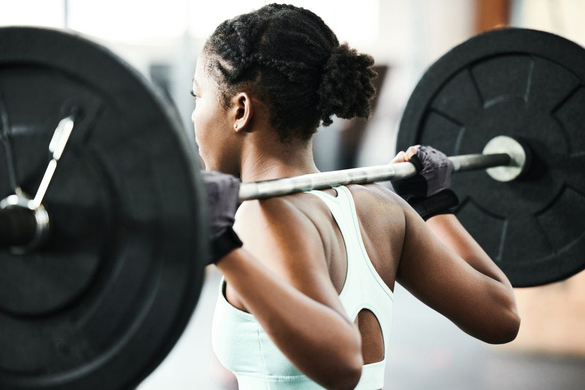 Woman with a heavy barbell across her shoulders 