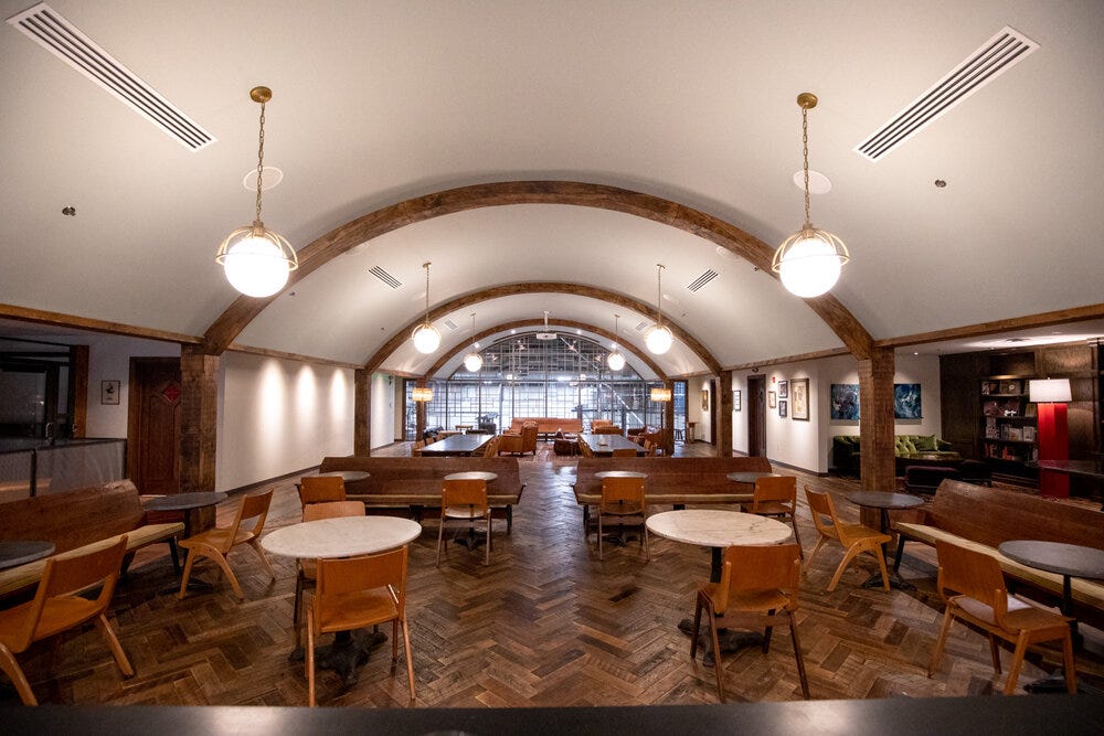 The upstairs area at Bold Monk Brewing Co. At the far end: the intricate Mondrian-influenced glasswork framing the Abbey provides a bird’s eye view of the brewery and brewing process taking place below.