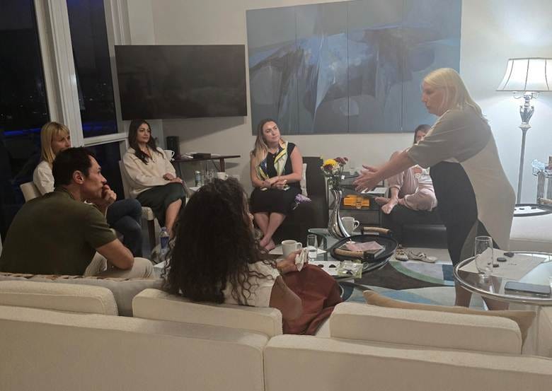 A group of people sitting in a room

AI-generated content may be incorrect.