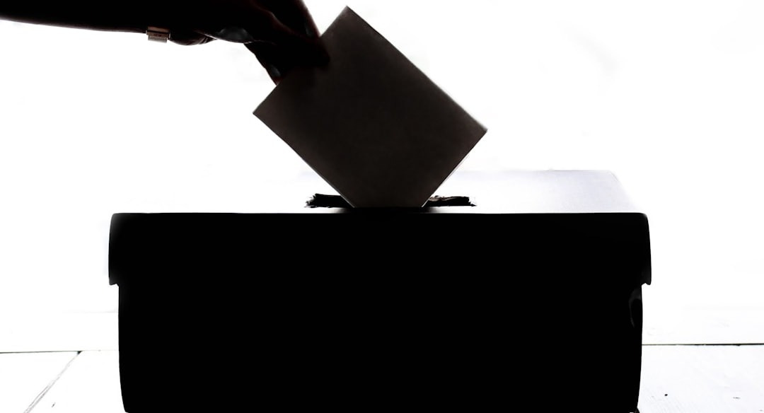 a person is casting a vote into a box