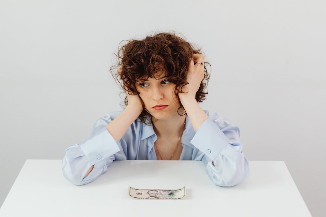 Free Woman in Blue Long Sleeve Blouse Near the Money on Table Stock Photo