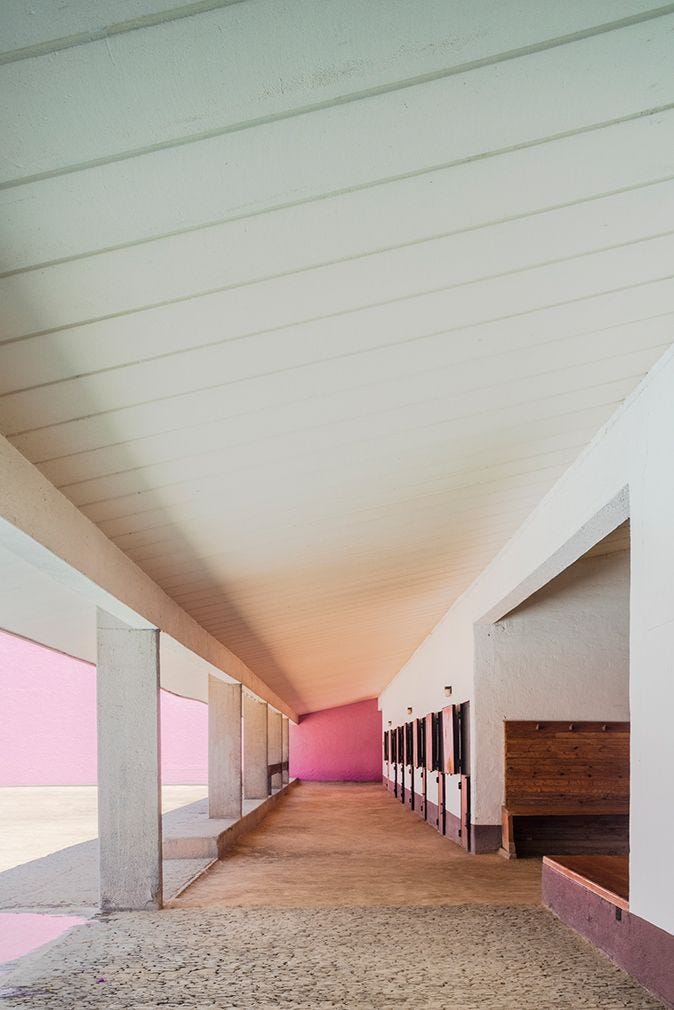 This may contain: an empty hallway with pink walls and benches on the side walk next to each other This may contain: an empty hallway with pink walls and benches on the side walk next to each other