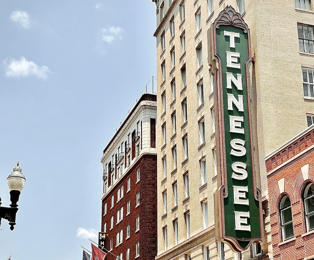 brown concrete building with green and white signage
