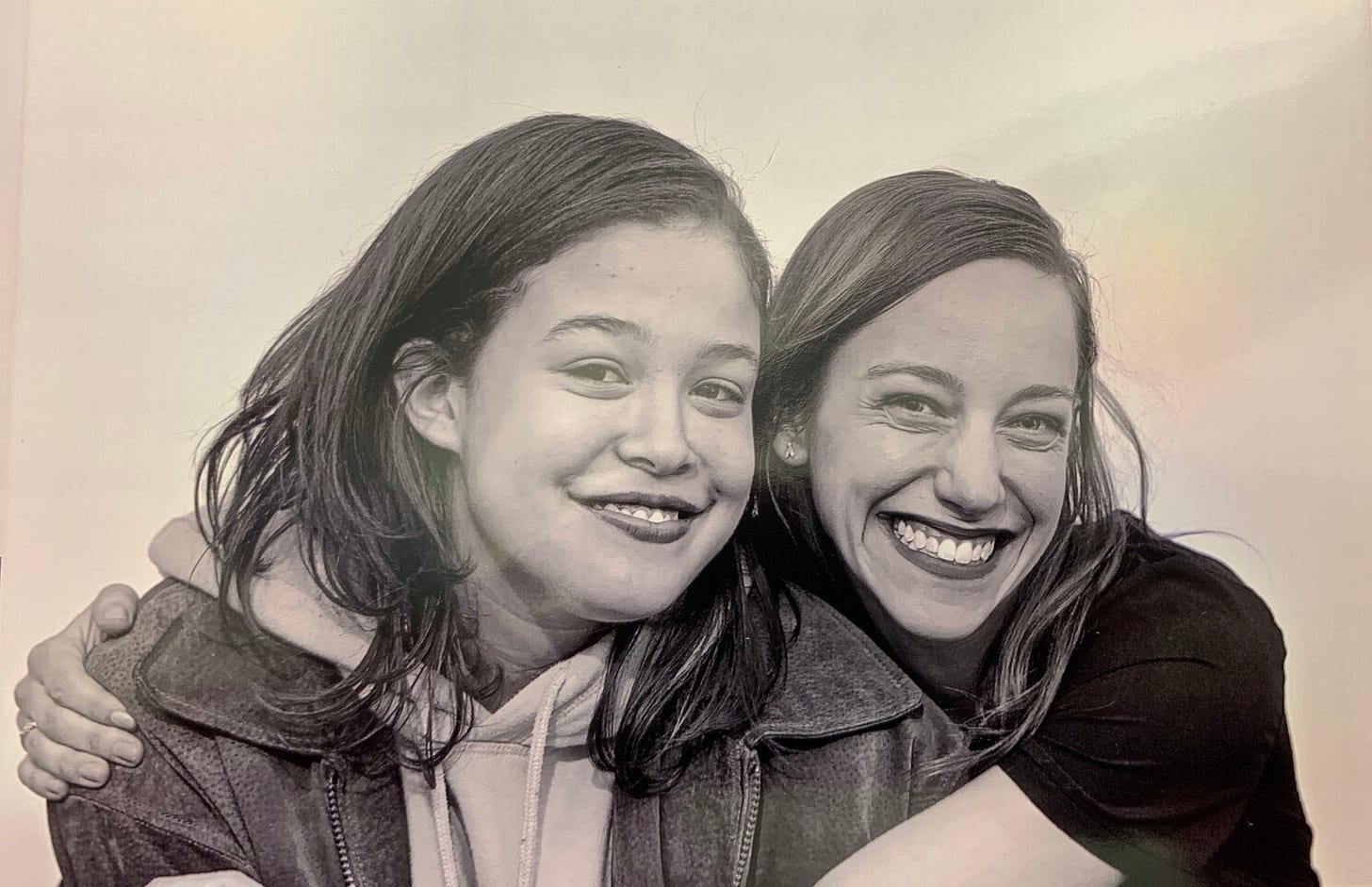 Sepia toned photo of Lauren and her mentee Saony, both smiling