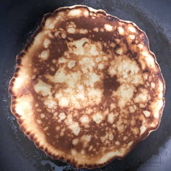 Pancake cooking in skillet.