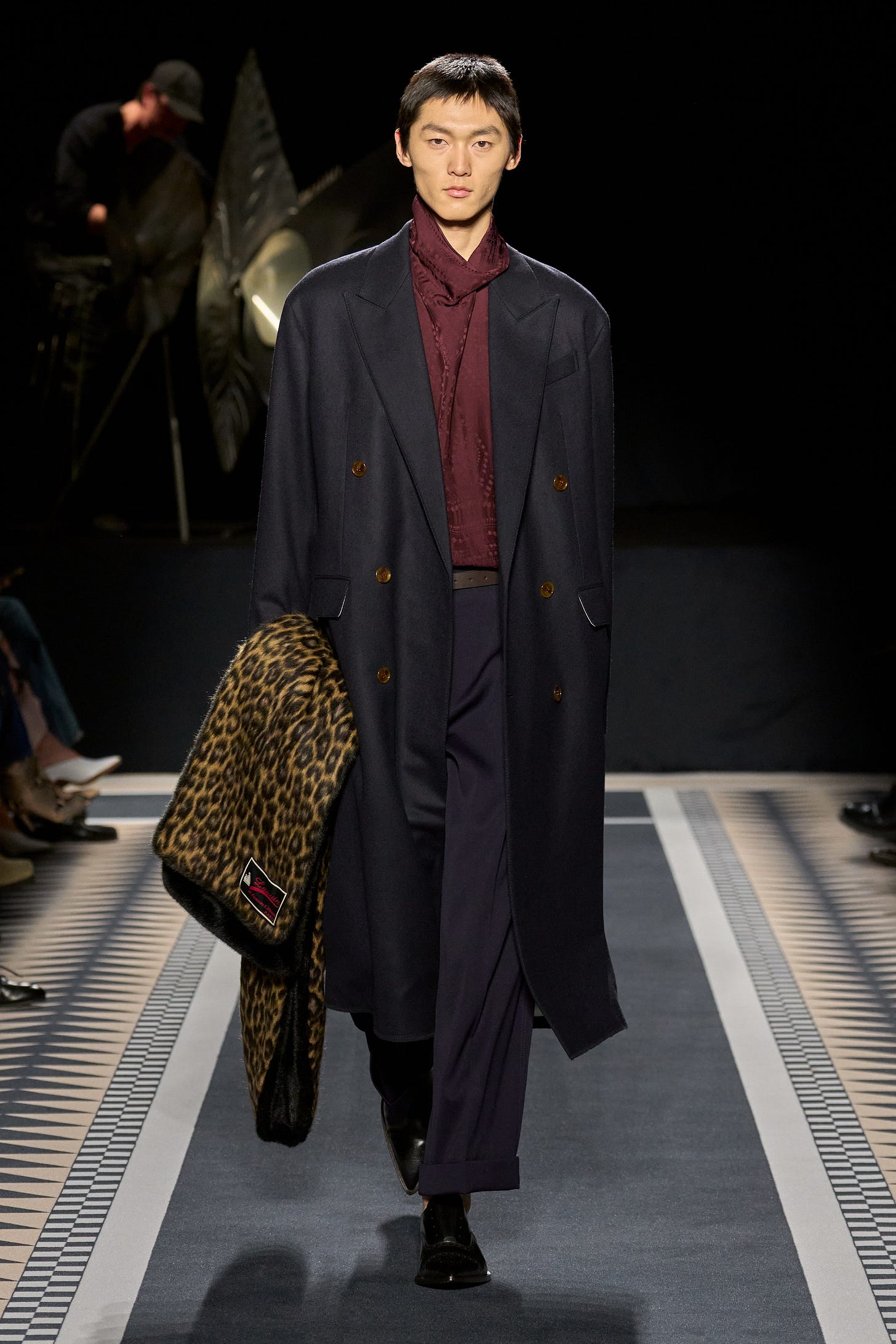 Image may contain Clothing Coat Fashion Hat Adult Person Overcoat Accessories Bag Handbag Footwear and Shoe