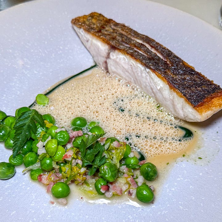 Crisp-skinned fillet of maigre over peas à la française with lardons in a frothy pea-pod sauce with gnocchi in bacon cream at Semilla
