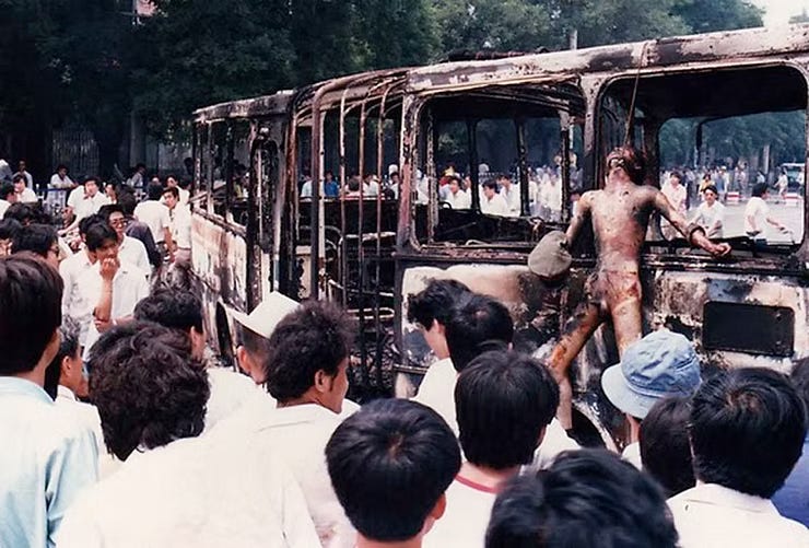 A People's Liberation Army (PLA) soldier, stripped nude and burnt alive, was hung by the neck to a charred bus.