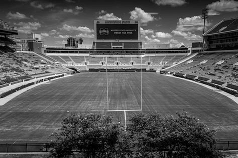 Mississippi State football stadium, campus with American flag, cowbell