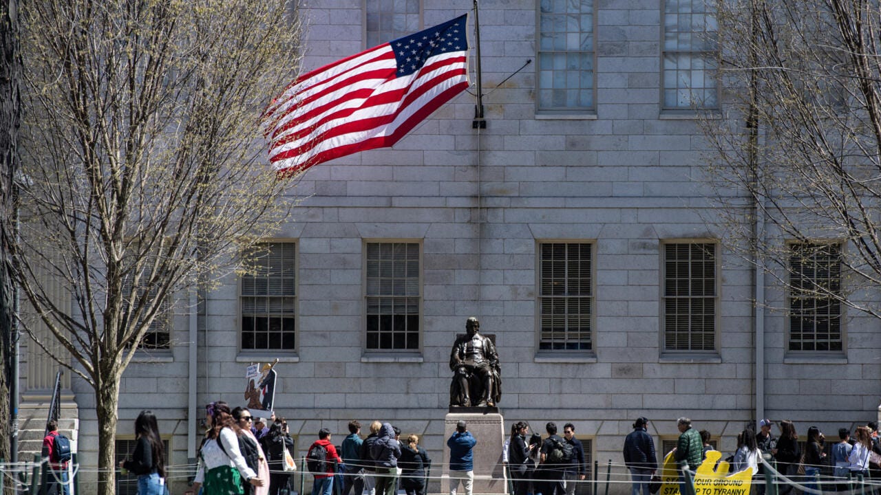 Demonstrators with signs stand in Harvard Yard following a rally against President Donald Trump's attacks on Harvard University in Cambridge, Massachusetts on April 17, 2025 Demonstrators with signs stand in Harvard Yard following a rally against President Donald Trump's attacks on Harvard University in Cambridge, Massachusetts on April 17, 2025