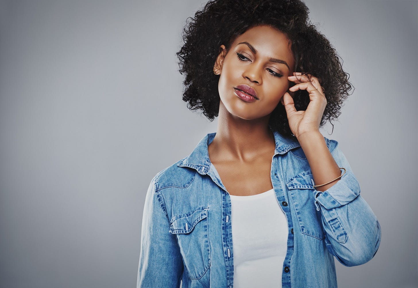 A beautiful woman tilts her head in self-doubt.