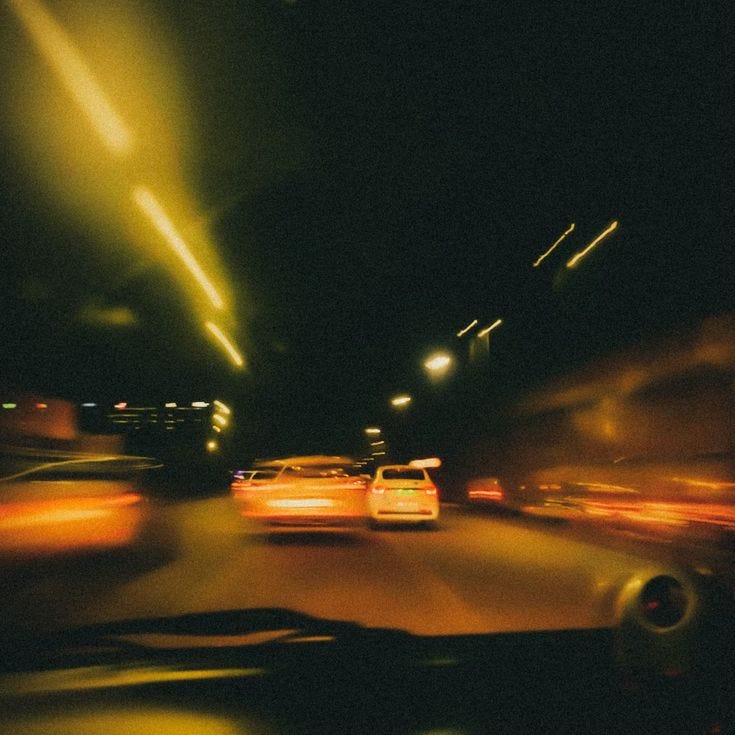 This may contain: blurry image of cars driving down the street at night