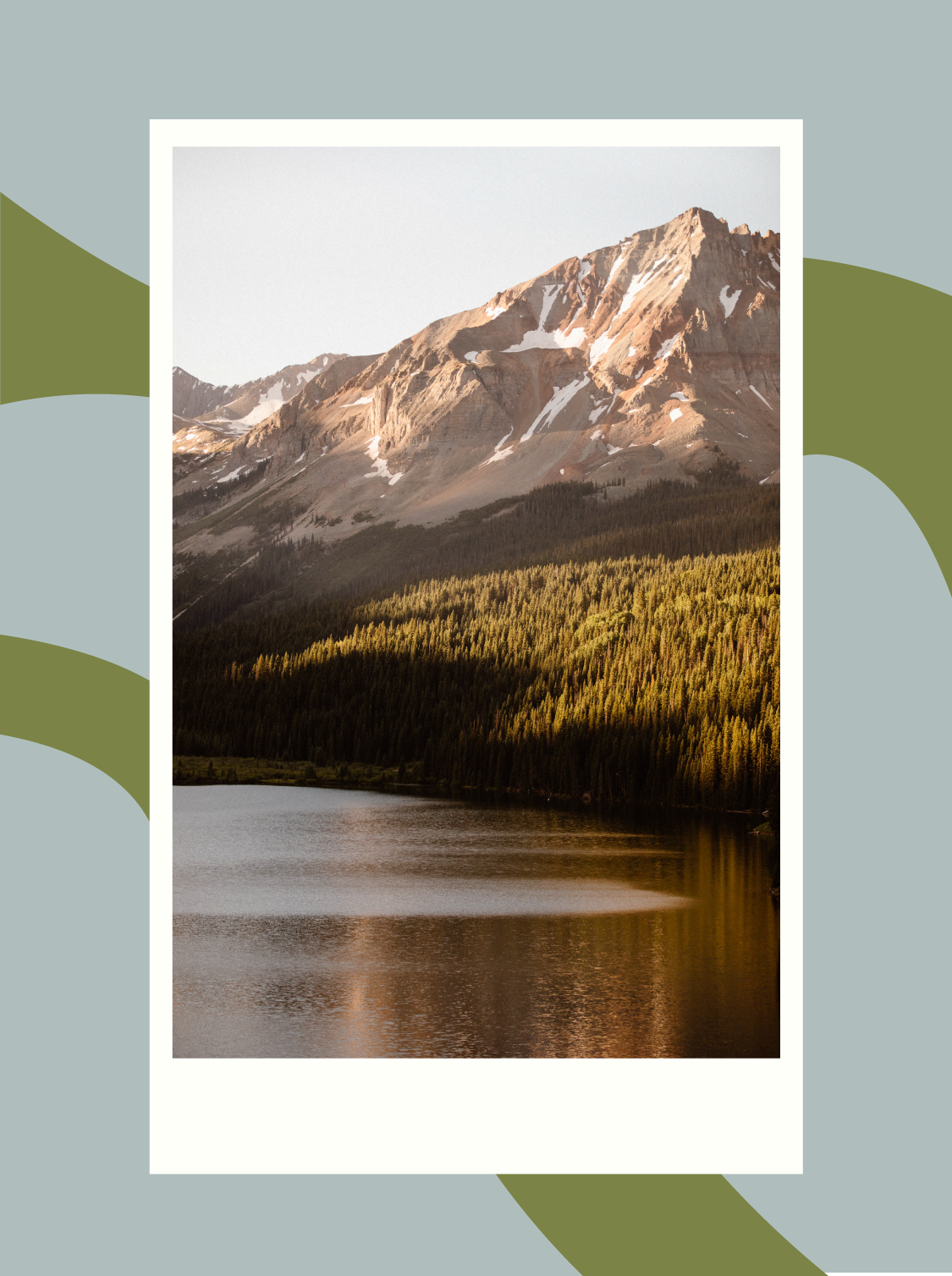 golden hour alpenglow light kissing the mountains towering above a tree-lined alpine lake