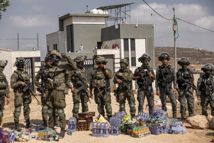 Israeli soldiers and Border Police officers standing in front of the besieged home in Qusra, in front of water and food that Israeli solidarity activists attempted to deliver, on Friday.