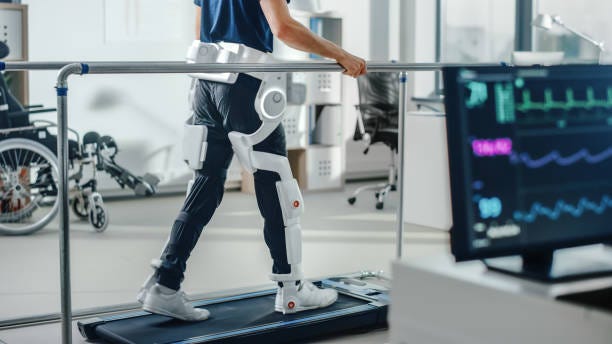 Modern Hospital Physical Therapy: Patient with Injury Walks on Treadmill Wearing Advanced Robotic Exoskeleton Legs. Physiotherapy Rehabilitation Technology to Make Disabled Person Walk. Focus on Legs Modern Hospital Physical Therapy: Patient with Injury Walks on Treadmill Wearing Advanced Robotic Exoskeleton Legs. Physiotherapy Rehabilitation Technology to Make Disabled Person Walk. Focus on Legs robotic rehabilitation stock pictures, royalty-free photos & images