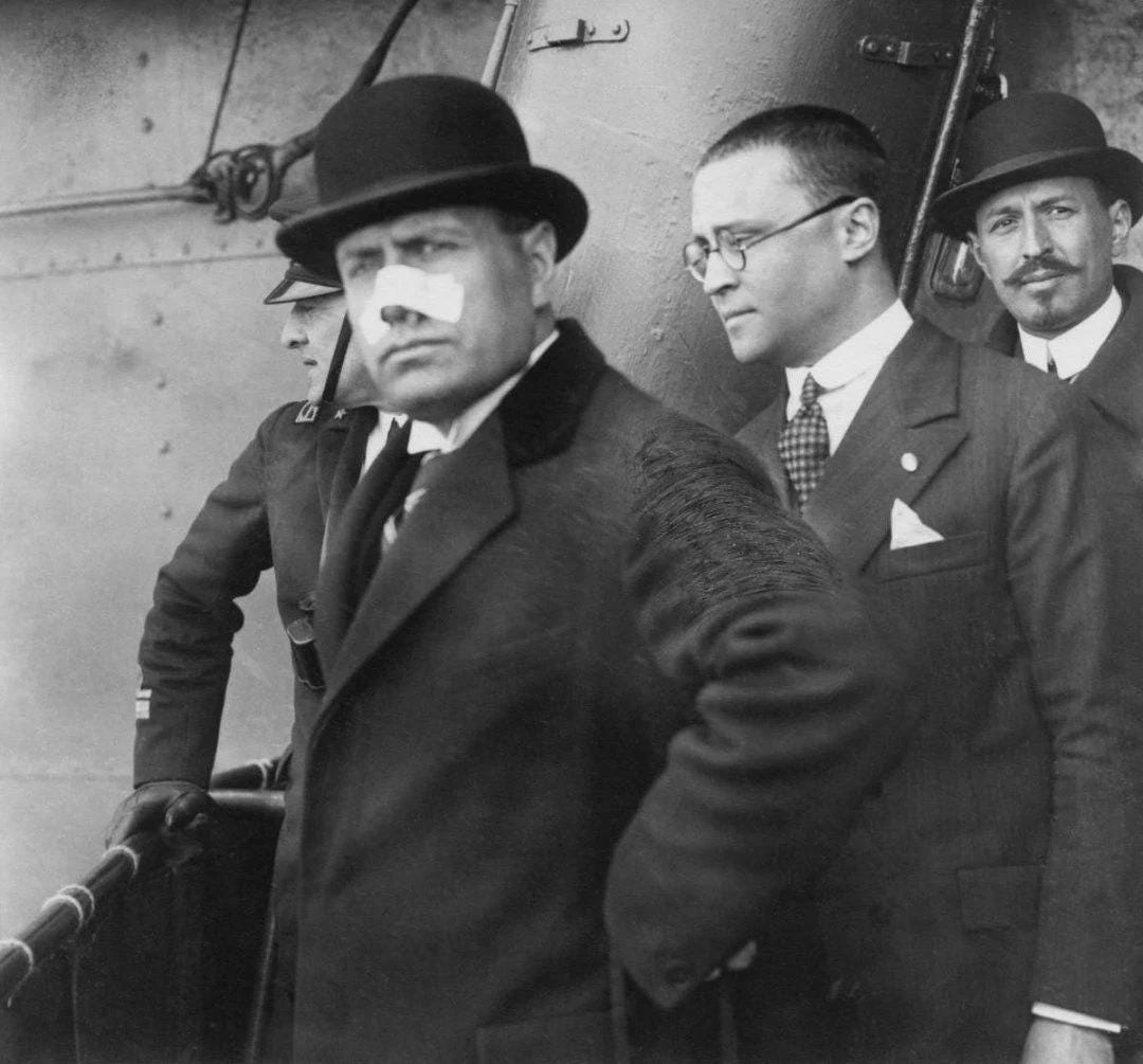 The immediate aftermath: Benito Mussolini photographed after an assassination attempt during a rally, showing a grazed nose. The immediate aftermath: Benito Mussolini photographed after an assassination attempt during a rally, showing a grazed nose.