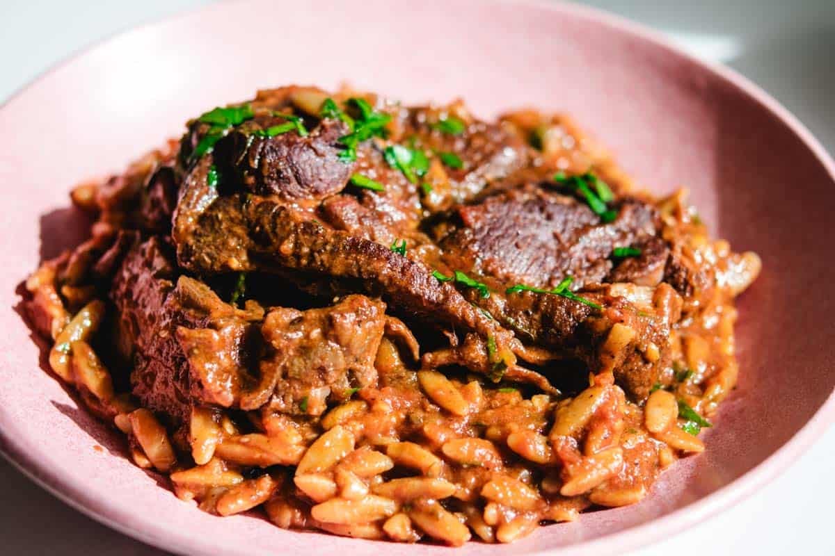 Lamb Manastra on a pink round plate Lamb Manastra on a pink round plate