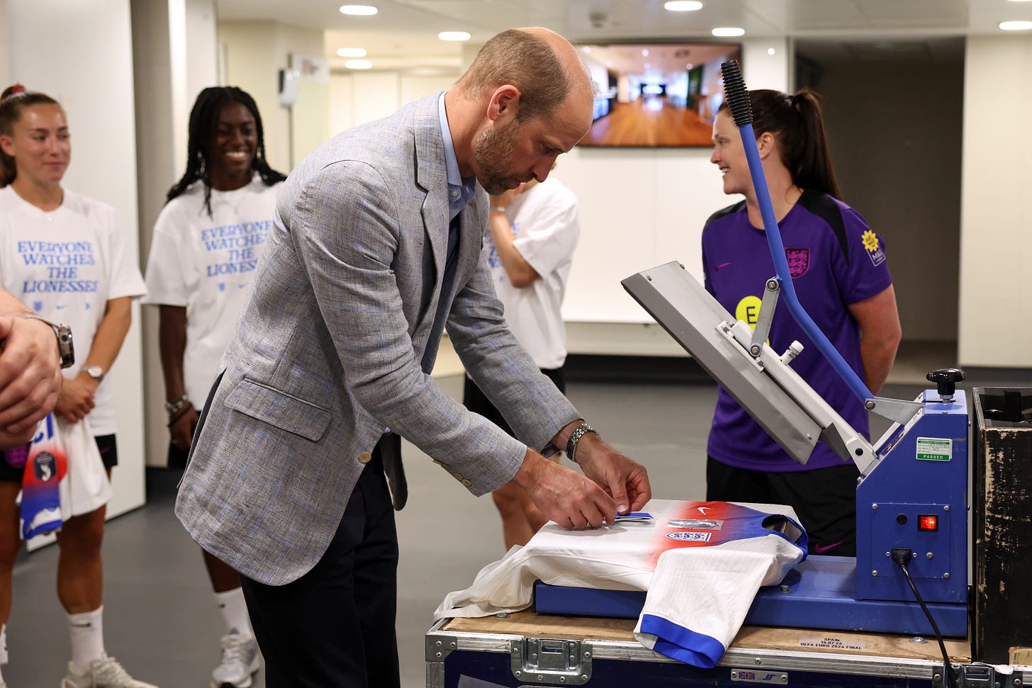 Prince William putting a number on a shirt