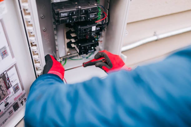 Electrician Working on Solar Panel Specific Electrical Panel A Solar Energy Technician works on wiring and connections on an electrical breaker box on the exterior of a home for a solar panel installation. electric panel installation stock pictures, royalty-free photos & images