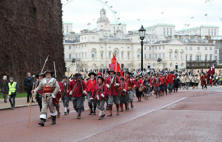 People in red royalist costumes marching past Horse Guards Parade People in red royalist costumes marching past Horse Guards Parade