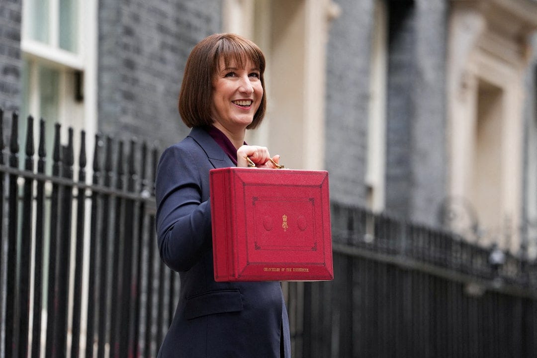 Britain's Chancellor of the Exchequer Reeves carries the red budget box at Downing Street, in London