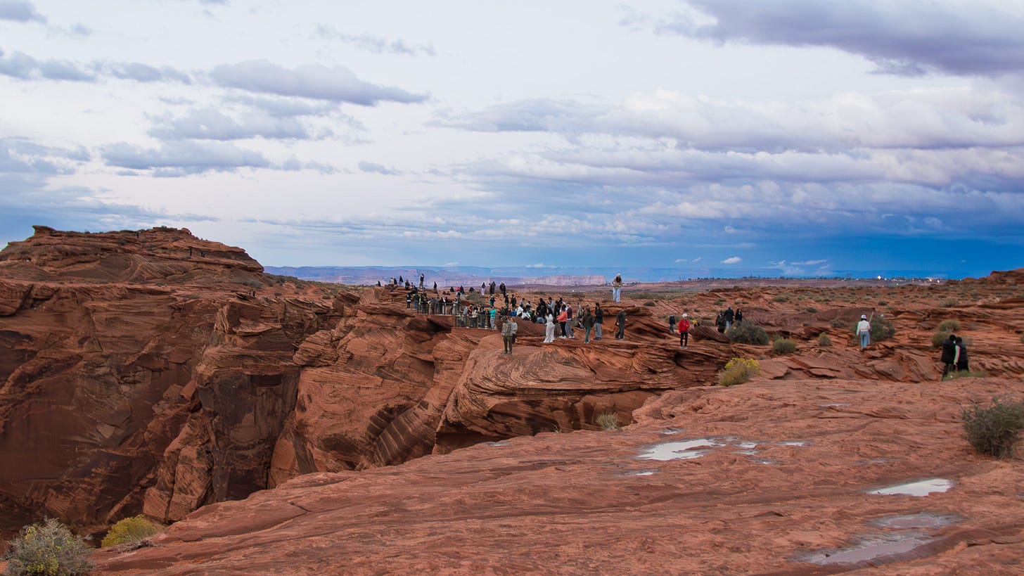 tourists trying to take pictures at the edge of Horseshoe bend tourists trying to take pictures at the edge of Horseshoe bend