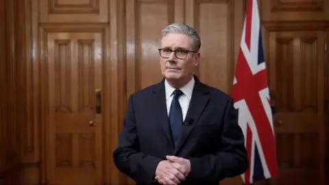 Keir Starmer in front of a union jack flag Keir Starmer in front of a union jack flag