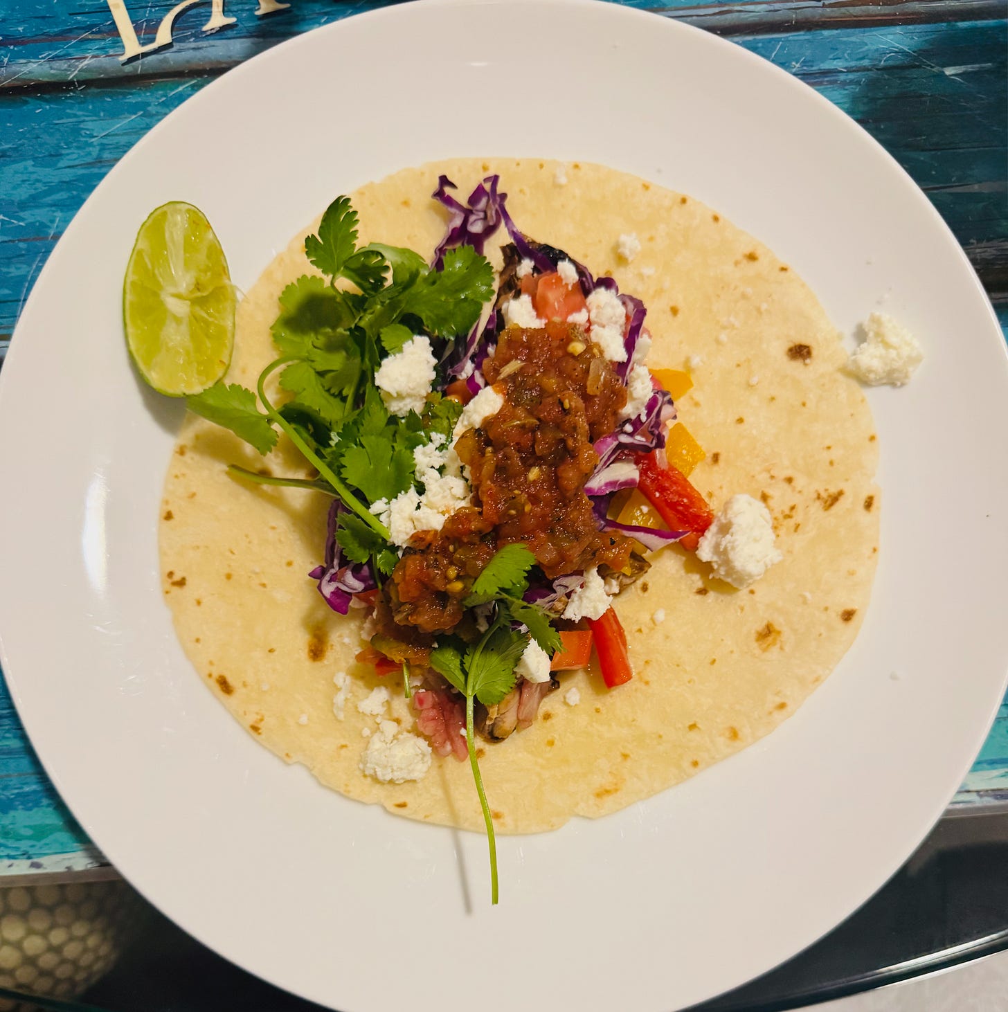 An open-faced soft taco with leftover grilled pork, red cabbage, salsa, Cotija, and cilantro. An open-faced soft taco with leftover grilled pork, red cabbage, salsa, Cotija, and cilantro.