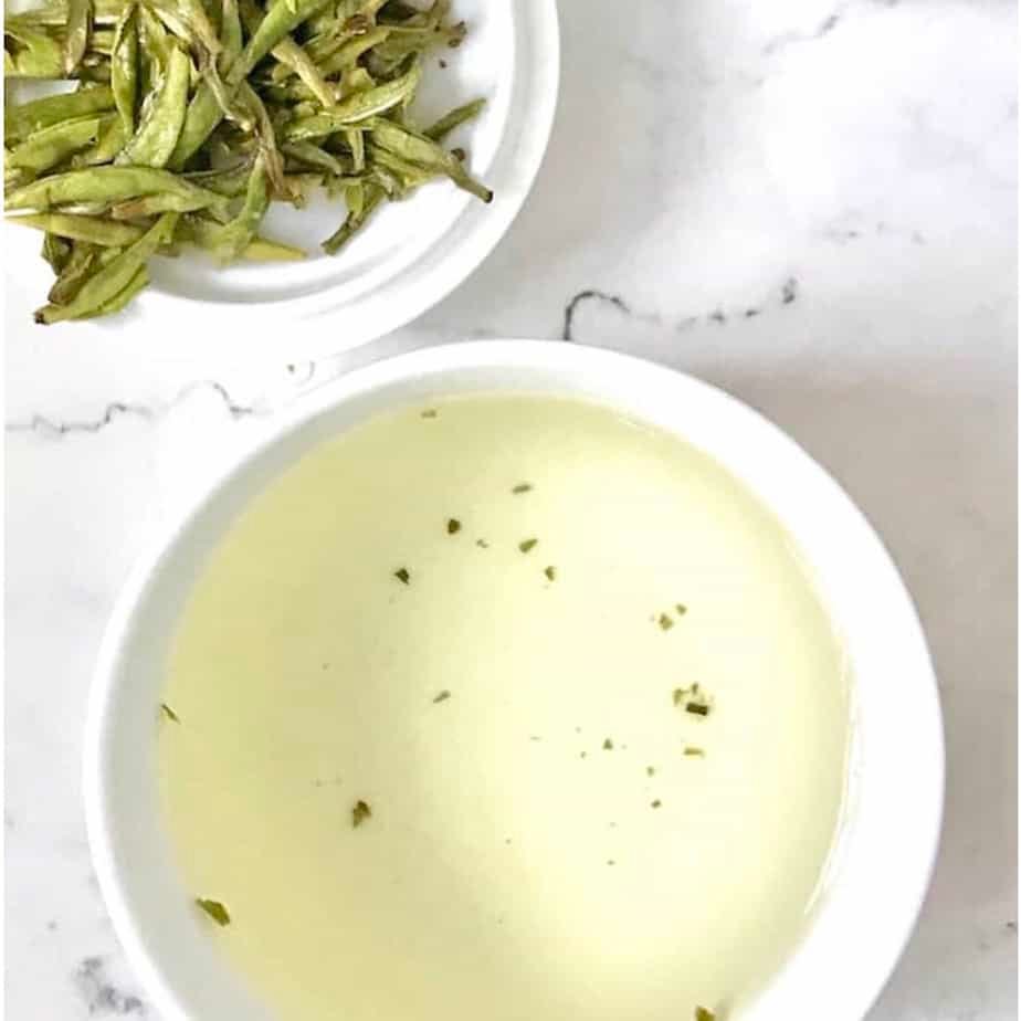 brewed cup of silver needle white tea and leaves